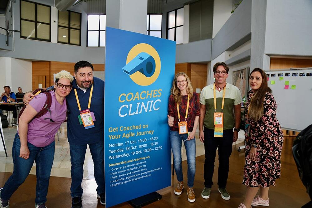 A group in front of the Coaches Clinic sign at the Global Scrum Gathering Lisbon