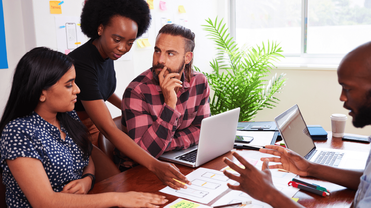 A group of colleagues sits around a table to collaborate at the office